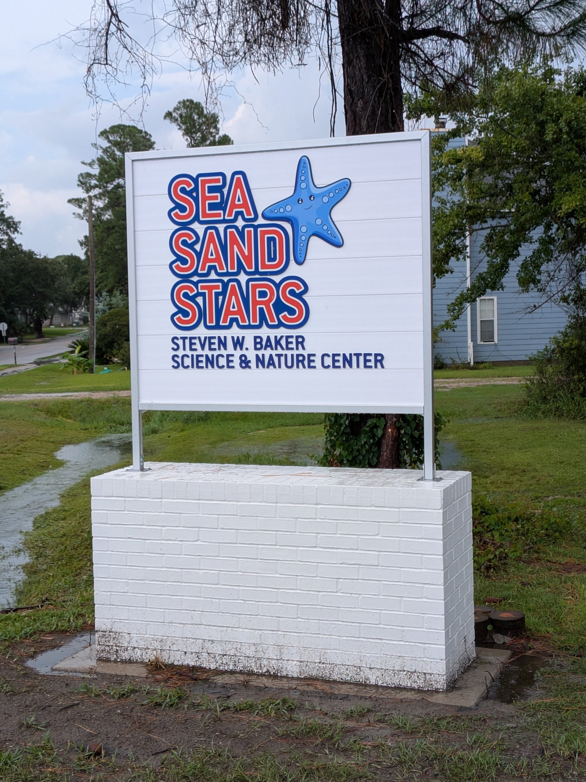 Sign for Sea Sand Stars Science & Nature Center with a blue starfish graphic.