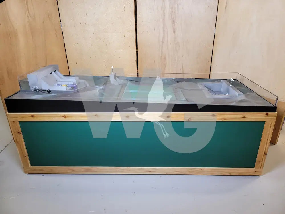 Display case with a green interior and black top against a wooden background